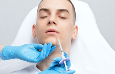 The cosmetologist makes injections for lip augmentation and anti-wrinkle in the nasolabial folds of...
