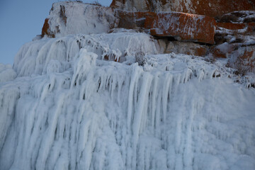 Shore covered with ice washes and icicles on Lake Baikal on a winter day.