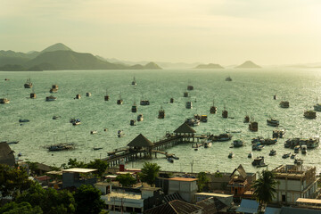 Tour Boats anchored at port of Labuan Bajo during sunset.