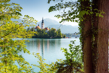 Landscape of Slovenia. A view of Lake Bled. Through the foliage of the shore, one can see The...