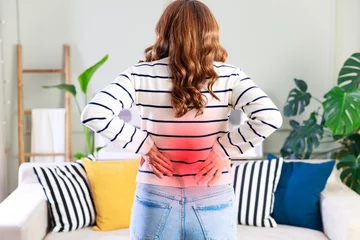 Fotobehang Young woman suffering from lower back pain © dragonstock