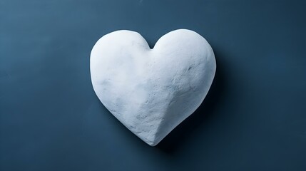 Top View of a White Stone Heart on a navy blue Background. Romantic Template with Copy Space