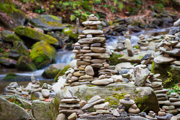 The stacked balanced stones near the mountain river. The mental health meditation practice. - 696875913