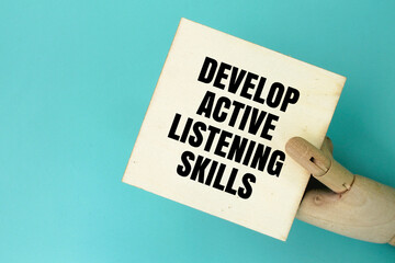 hand holding a board with the words Develop active listening skills