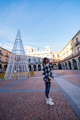 Caucasian woman explores Ávila's historic square.