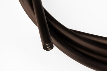 black fiber optic cable for internet connection on a white background close-up