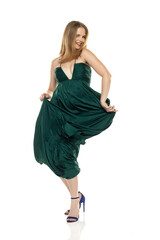 Naklejka premium Full body front view portrait of elegant lovely blond lady dancing isolated on white background in green long dress