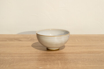 Handmade ceramic on a wooden table. White wall background. product photography.