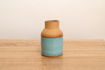 Handmade ceramic on a wooden table. White wall background. product photography.