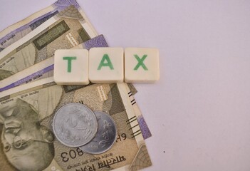 A closeup picture of a Indian currency notes with word Tax.