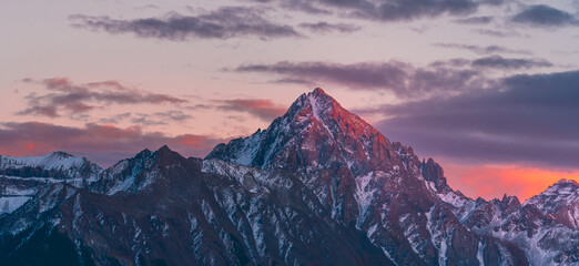 Close Up Colorado Mountain Peak with Vibrant Sunrise Purple Red Light at Dallas Divide. Snow Covered Mountain Peaks.