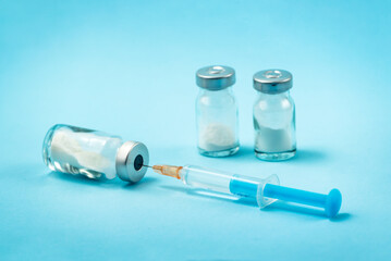 Syringe and needle with glass medical ampoule vials for injection. Medicine is dry white drug...
