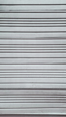 Metal wall with horizontal lines. Metal roller door used in storage, garage, and industrial warehouse.