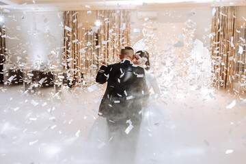 the wedding of the bride and groom in an elegant restaurant with great light and atmosphere. The first dance of the bride and groom. - obrazy, fototapety, plakaty