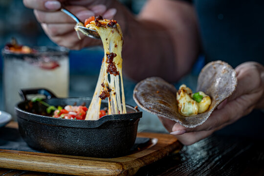 Queso Fundido. Oaxaca and chihuahua cheese on a
skillet with chorizo and pico de gallo, served with blue corn tortillas