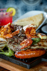 Parrillada de Sonora -Northern-style mixed grill with carne asada steak, mesquite chicken breast, chorizo links, spicy shrimp, Asadero cheese, cactus
paddles, grilled onions, and chile toreado