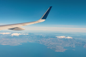 Obraz premium View of a snowy mountain from a window in airplane.