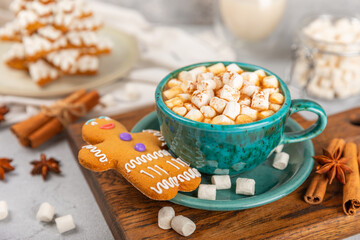 Hot drink with marshmallows and candy cane in blue cup on texture table.Cozy seasonal holidays.Hot cocoa with gingerbread Christmas cookies.Hot chocolate with marshmallow and spices.Copy space.