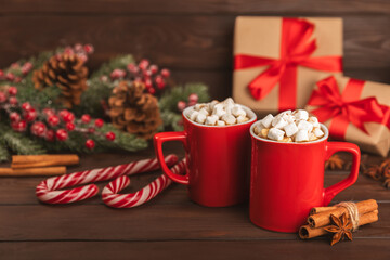 Hot drink with marshmallows and candy cane in cup on texture table.Cozy seasonal holidays.Hot cocoa with gingerbread Christmas cookies.Hot chocolate with marshmallow and spices.Copy space.