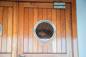 Porthole in the door on the ship. Cruise ship design. Passenger ship details. Round window, deck view