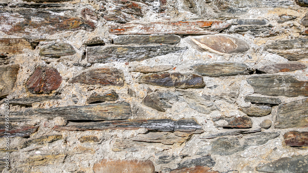 Sticker Close-up texture of an old stone wall with embedded wooden beams, possibly related to historical building techniques or architecture