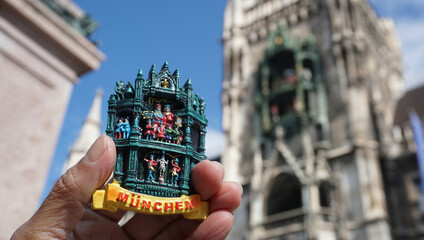 person holding a colorful refrigerator magnet of Munich, Germany