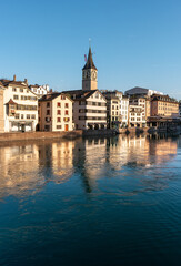 Zurich, Switzerland. Cityscape of the embankment with houses and the clock tower of St. Peter's Church.