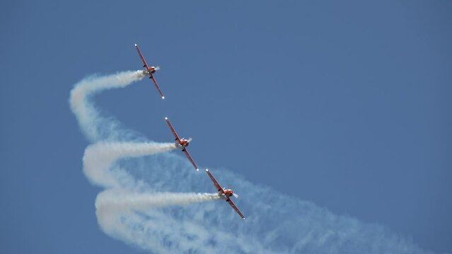 professional pilots of sport aircraft shows tricks in sky, leaving traces of clouds,  Lithuania