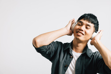Portrait of a cheerful man holding his phone and wearing Bluetooth headphones, fully immersed in the world of modern technology and music. Studio shot isolated on white.