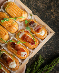 Gourmet stuffed eclairs with cream, prosciutto, and greens on a rustic background, illustrating the concept of high-end culinary treats