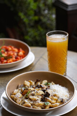 Pappardelle pasta with mushrooms and parmesan cheese on a plate . Traditional Italian gnocchi pasta with mushroom and parmesan cheese