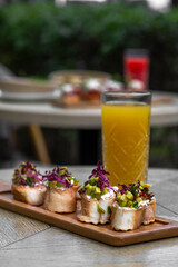 Canapes with avocado, mozzarella cheese and sauce on wooden board . bruschetta