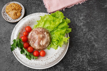Homemade jellied meat with mustard and horseradish on the table. Aspic. Homemade jelly with mustard, tomatoes and garlic on the table. Kholodets, traditional Russian food
