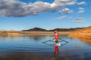 Senior male rower is standing in a coastal rowing shell - Horsetooth Reservoir in fall or winter...