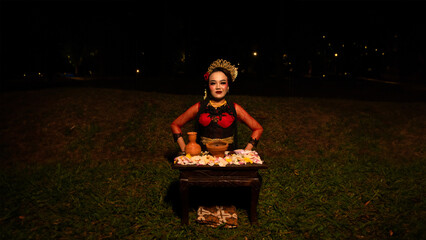 a female dancer performs a ritual that creates a magical and mystical atmosphere in front of flower...