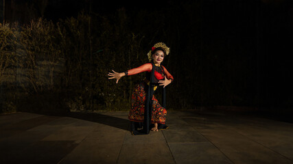 an Asian dancer dancing in front of the yard in a red costume