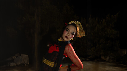a Javanese dancer dressed in traditional red clothes enchanted the audience with her graceful...