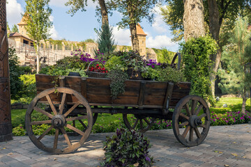 Various flowers in baskets on a cart in autumn.