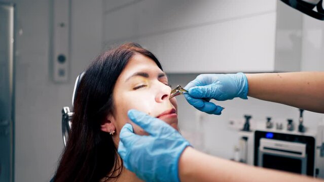 close-up ENT doctor examines the nasal cavity of the patient in the office of the clinic with professional tools