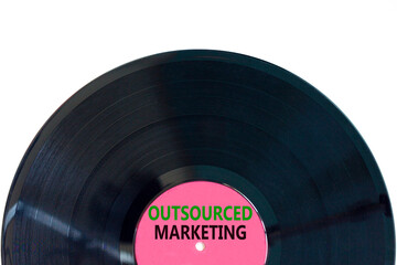 Outsourced marketing symbol. Concept words Outsourced marketing on beautiful black vinyl disk. Beautiful white table white background. Business Outsourced marketing concept. Copy space.