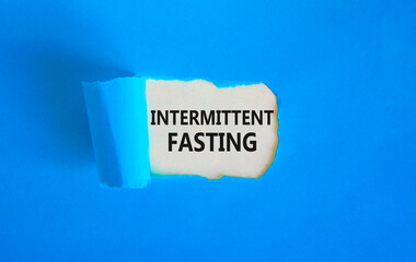 Intermittent fasting symbol. Concept words Intermittent fasting on beautiful white paper. Beautiful blue background. Healthy lifestyle intermittent fasting concept. Copy space.