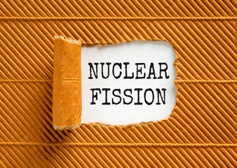 Nuclear fission symbol. Concept words Nuclear fission on beautiful white paper. Beautiful brown paper background. Business science nuclear fission concept. Copy space.