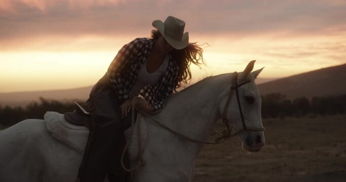 Woman, cowgirl and saddle on horse in sunset for travel, ride or transport in the countryside. Female person or farmer riding animal for outdoor adventure, journey or natural trip in nature scenery