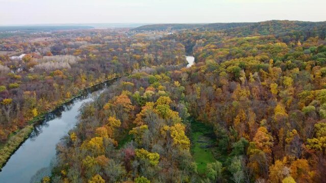 Autumn aerial forward flight above river with colorful forest on riverbanks. Cossack mountain on Siverskyi Donets River in Ukraine
