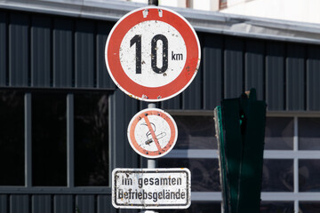 Verkehrszeichen Tempolimit 10 km/h Schrittgeschwindigkeit auf dem Gelände einer Fabrik