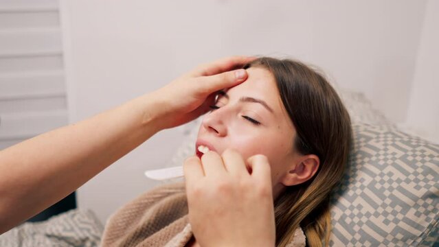 The ENT doctor examines the patient's oral cavity in the office of the polyclinic with professional tools