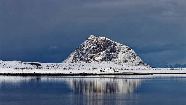 Lofoten winter landscape. The view of Hoven, the mountain in Gims&oslash;ya, and its reflection in still water in foreground.   Lofoten Islands, Northern Norway