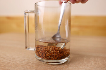 To prepare a therapeutic decoction, flax seeds are shaken in a glass of boiling water.