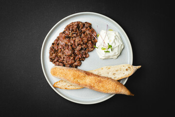 Appetizing veal tartare on a black background