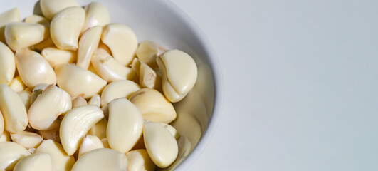 Peeled Chinese garlic in a white bowl